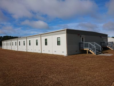 Exterior view of modular facility with multiple windows placed on Marine Corps Base Camp grounds