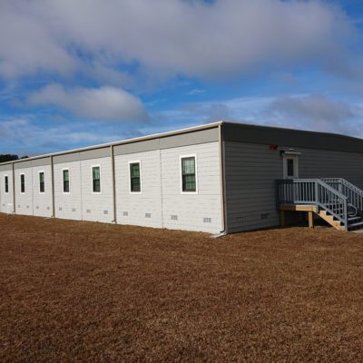 Exterior view of modular facility with multiple windows placed on Marine Corps Base Camp grounds